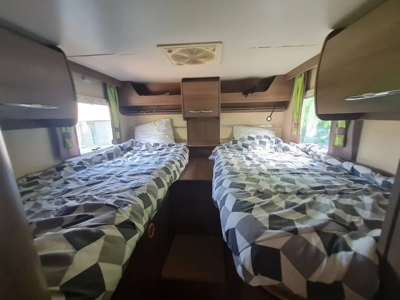 Lits jumeaux confortables dans un camping-car 4 places, prêts pour l'aventure.