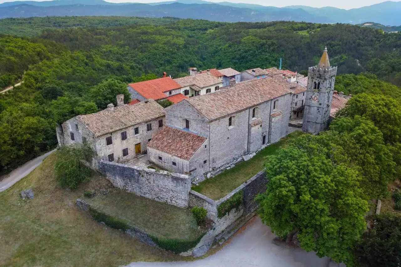 Das malerische Dorf Hum in Kroatien, eingebettet in grüne Hügel, mit seiner Kirche und dem Glockenturm.