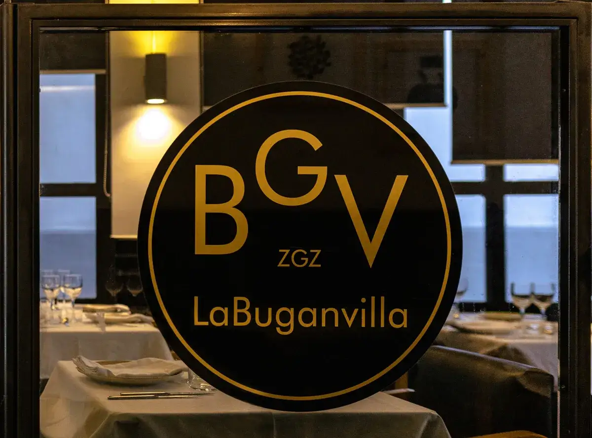 Logo circular negro con letras doradas 