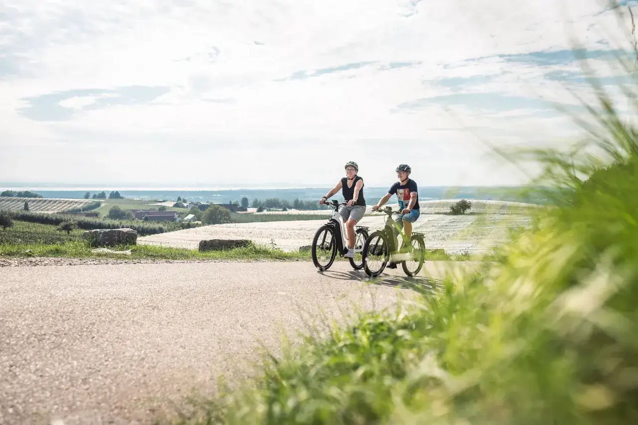 Zwei Radfahrer genie&szlig;en die Aussicht auf den Bodensee. Die Landschaft um den lac de constance l&auml;dt zum Radfahren ein.