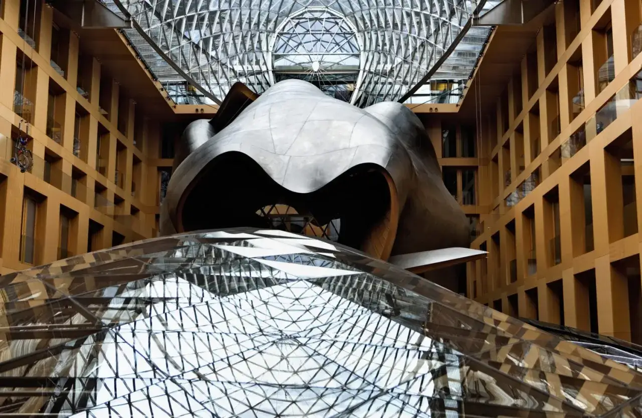 Futuristisches Gebäude mit geschwungener Metallstruktur und Glasdach, ein Werk bekannter Architekten.