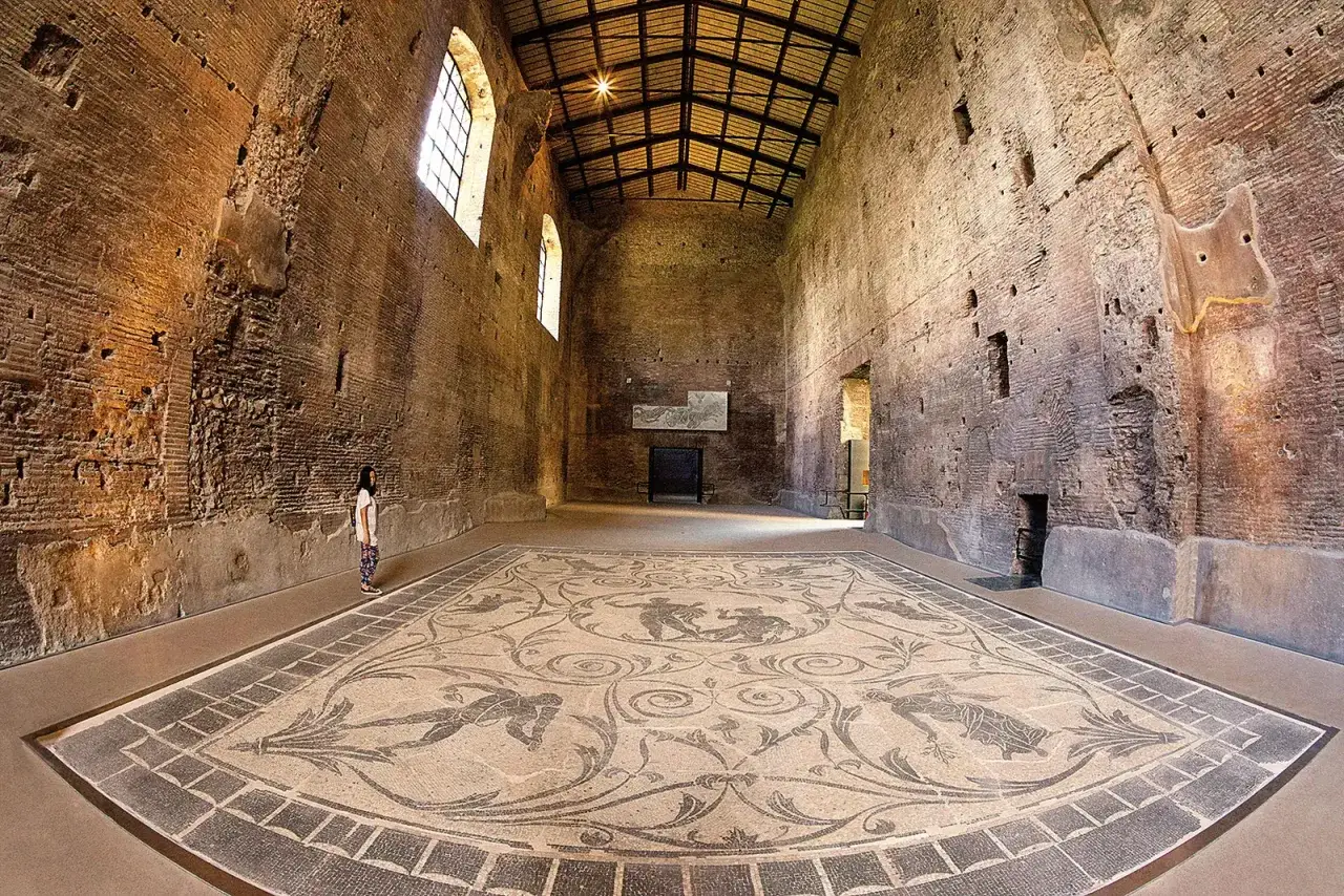 Ein M&auml;dchen bestaunt das antike Mosaik im Thermenkomplex von Ostia Antica.