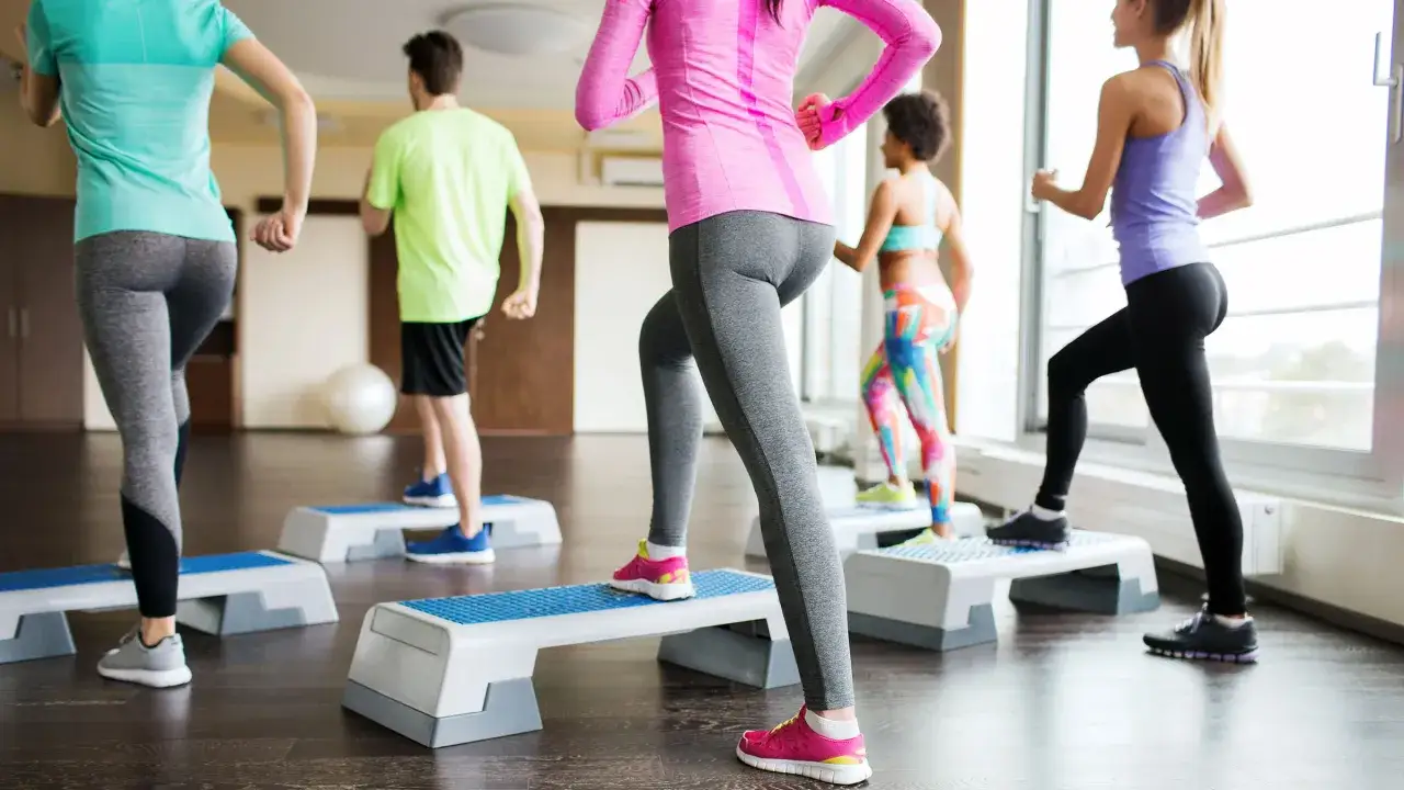 Groupe faisant du step à la maison, une séance de fitness dynamique pour rester en forme.