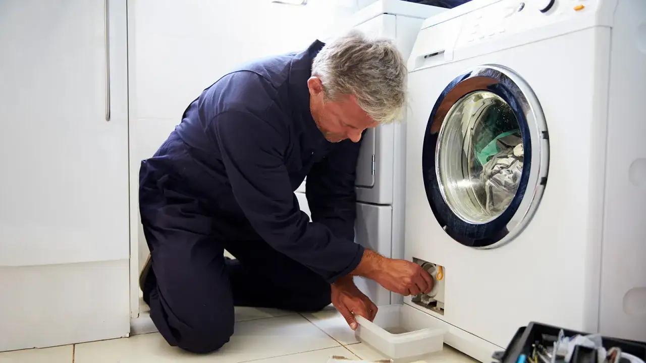 T&eacute;cnico revisa lavadora, asegurando la **garant&iacute;a lavadora**. Un profesional en acci&oacute;n, solucionando problemas.