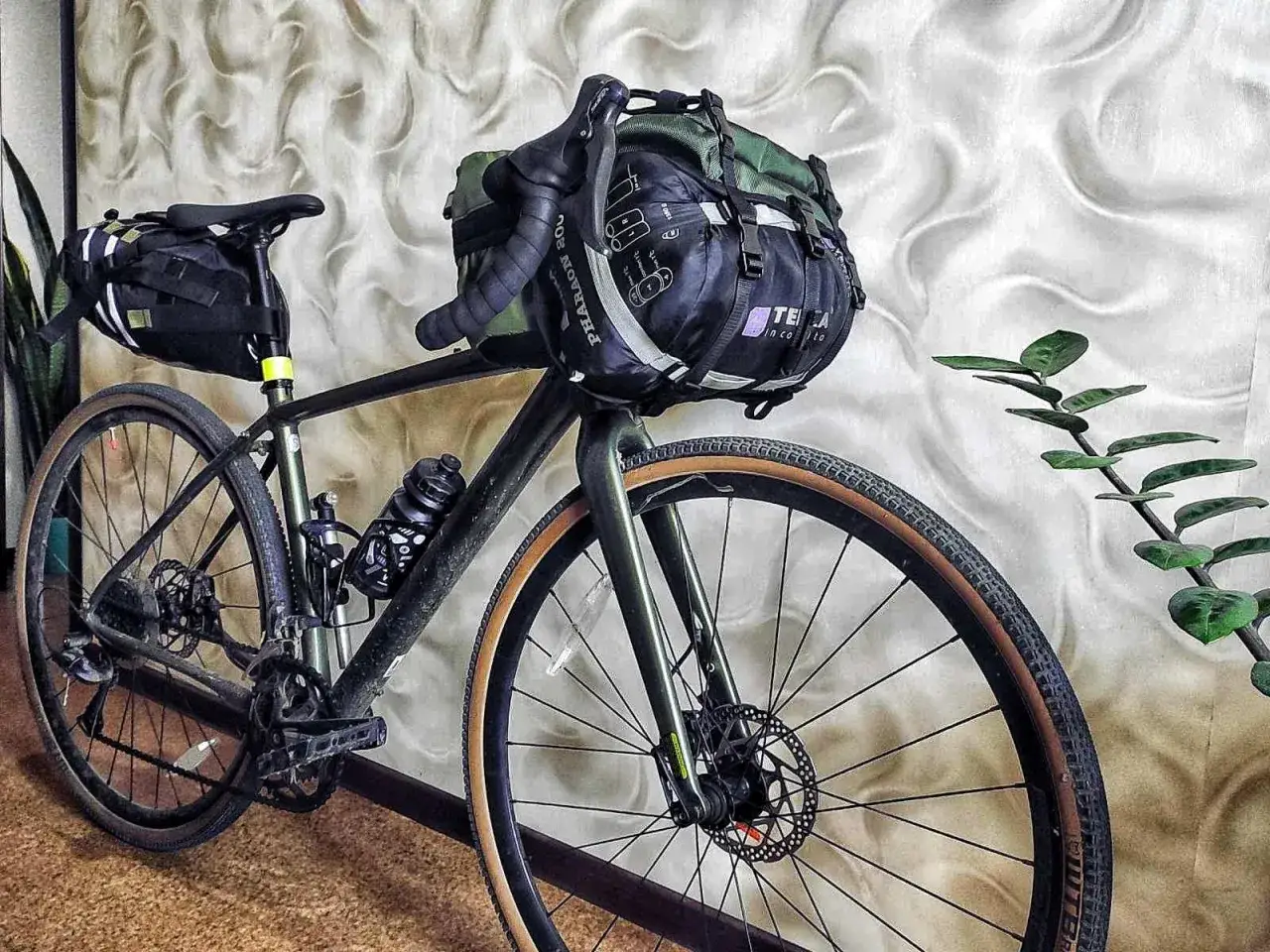 Fahrrad für Bikepacking mit Zelt verstaut. Lenker- und Satteltaschen sind gepackt, bereit für das nächste Abenteuer.
