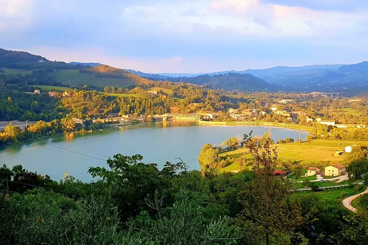 Lago di Fiastra, un gioiello nelle Marche, incastonato tra colline verdi e un borgo pittoresco.