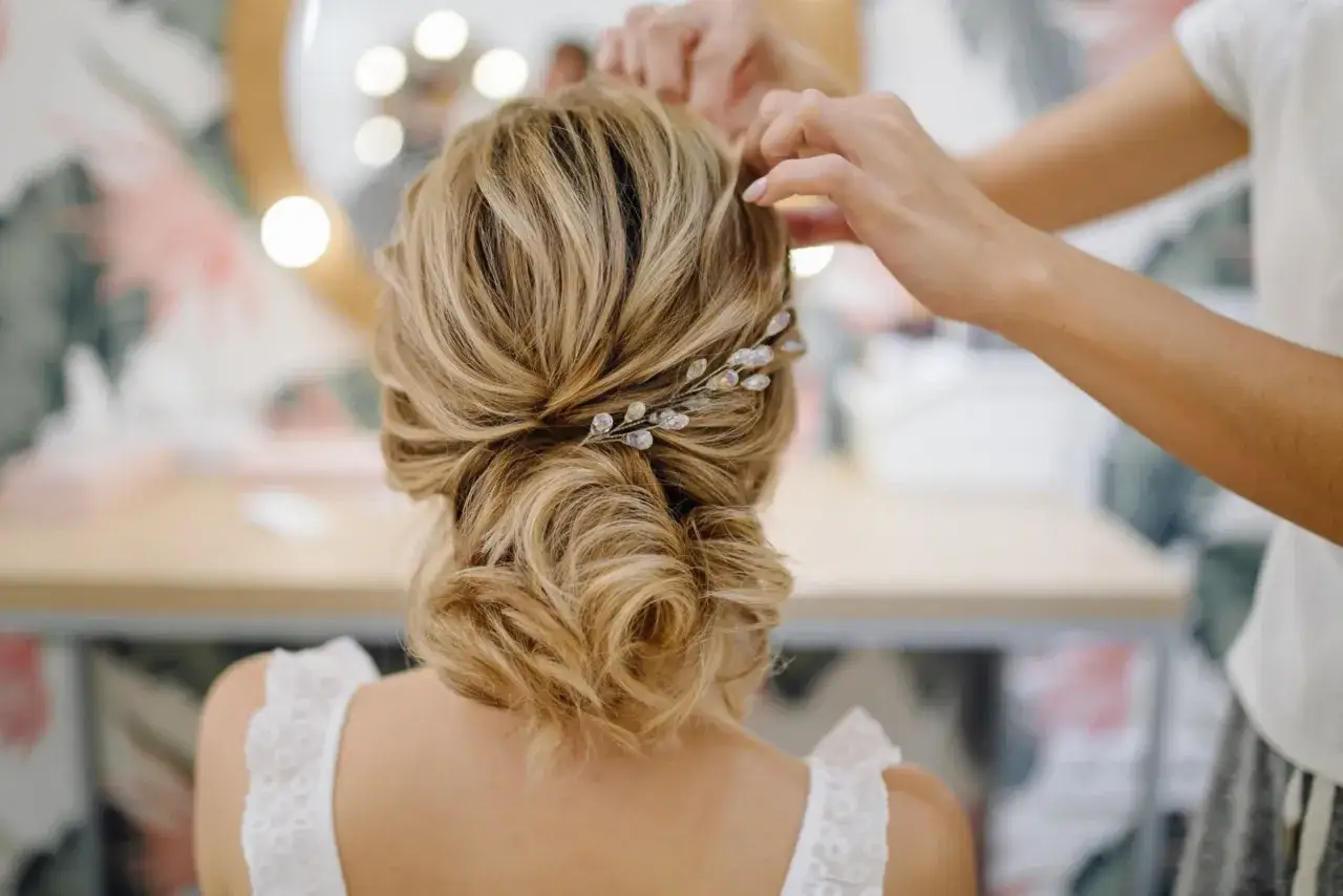 Une coiffure bohème chic avec des ondulations douces et une barrette ornée de perles.