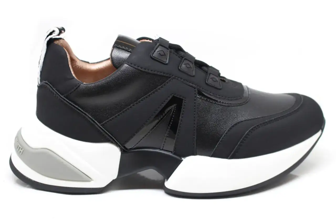 Sneaker Alexander Smith nere, con suola bianca e dettagli in vernice lucida. Stile moderno e audace.
