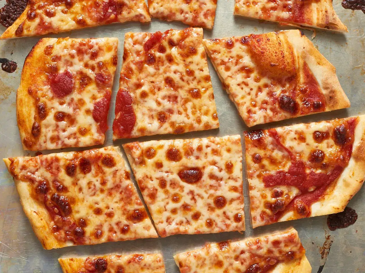 Kawałki pizzy z serem i sosem pomidorowym. Idealne, by zainspirować Cię, jak zrobić sos do pizzy.