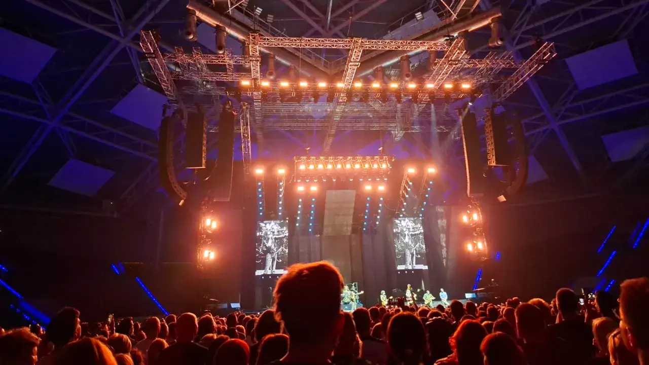 Koncert Lenny Kravitz w Łodzi. Tłum widz&oacute;w pod sceną, oświetloną pomarańczowymi światłami i ekranami z wizerunkiem artysty.