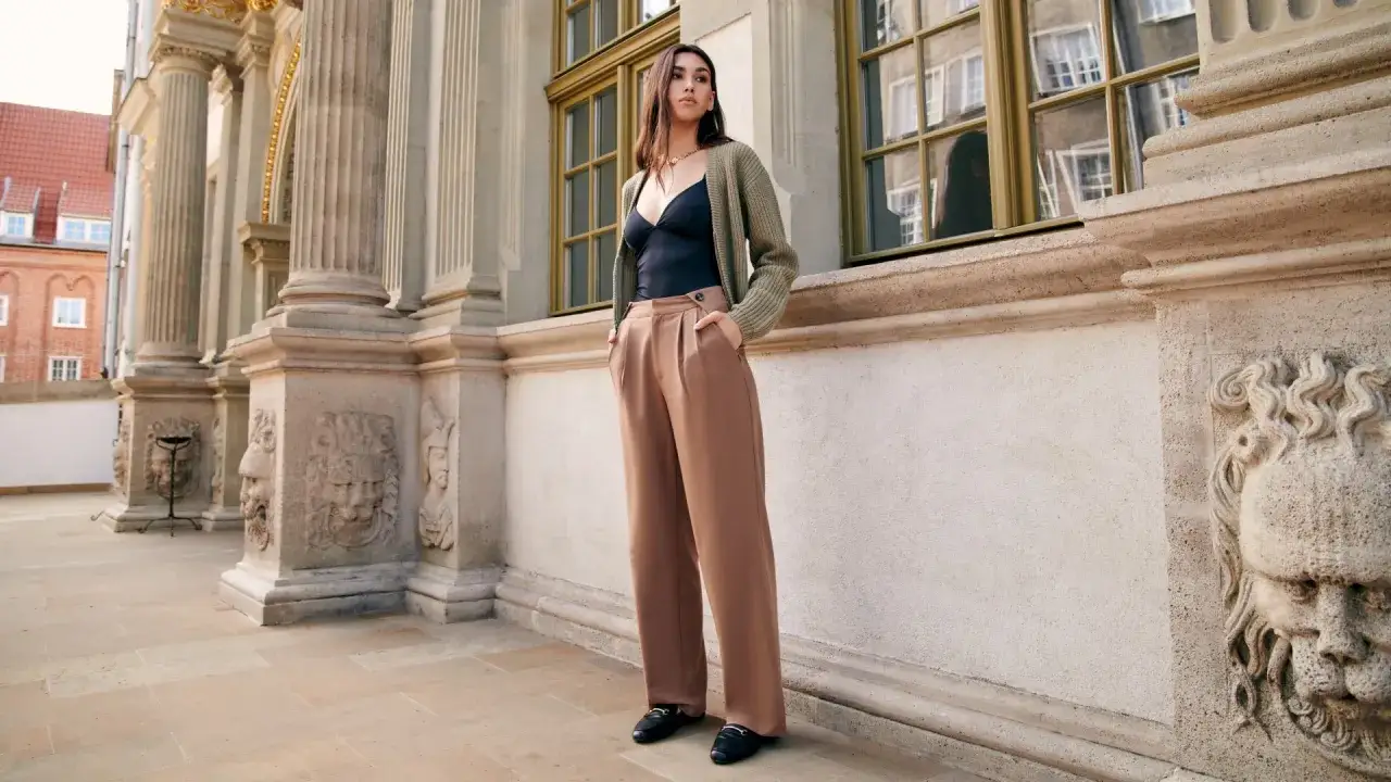 Elegancka stylizacja: czarny top, brązowe szerokie spodnie i czarne mokasyny. Idealne buty do szerokich eleganckich spodni.