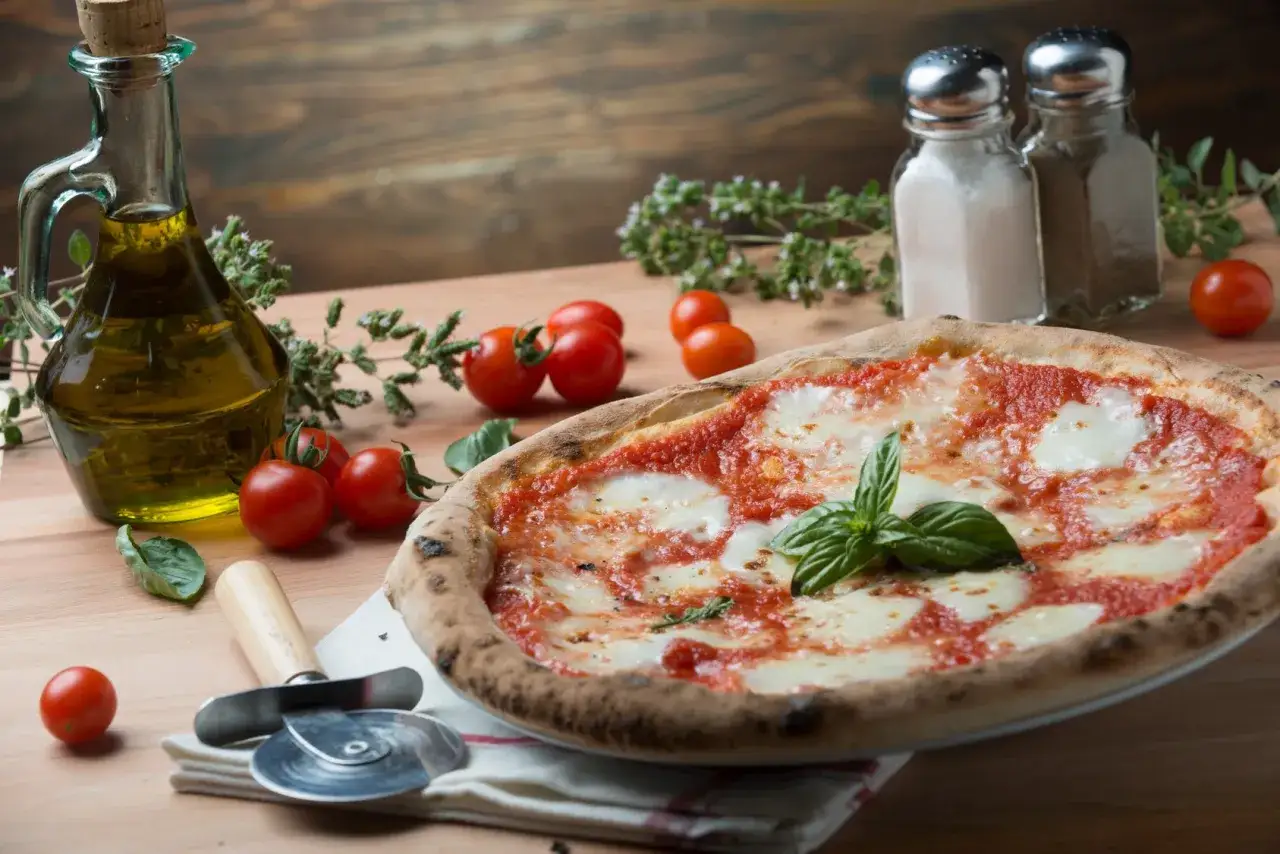 Pyszna pizza Margherita, oliwa, pomidorki i zioła – idealne składniki do kuchni włoskiej przepisy.