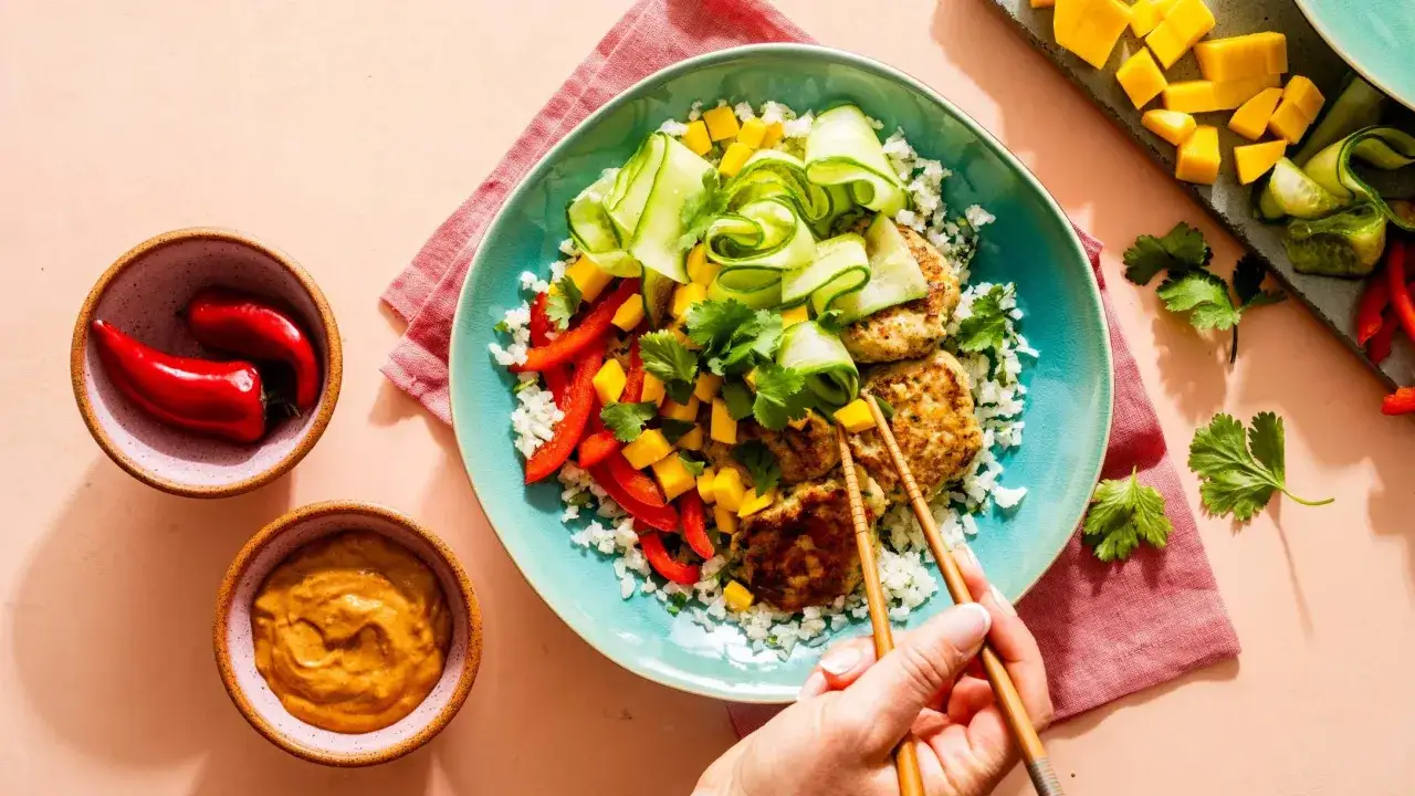 Patties di pollo su riso di cavolfiore con mango, peperoni e cetrioli, un piatto perfetto per la dieta low carb.