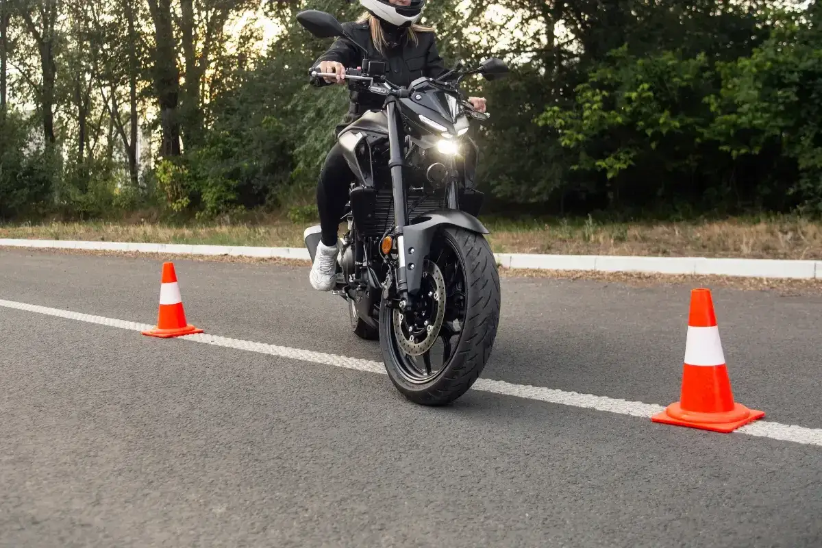 Person på motorcykel övar på en lågfartsbana mc, med koner utplacerade på asfalten.