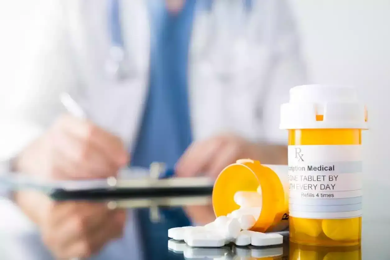 Lekarz przepisuje Depralin 5 mg. Tabletki wysypują się z pojemnika.