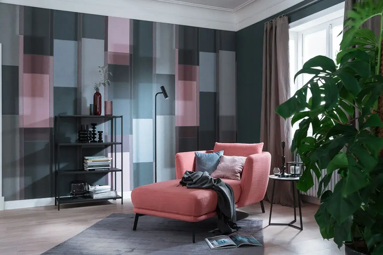 Gemütliches Wohnzimmer mit Koralle Farbe Chaiselongue, Bücherregal und moderner geometrischer Tapete.