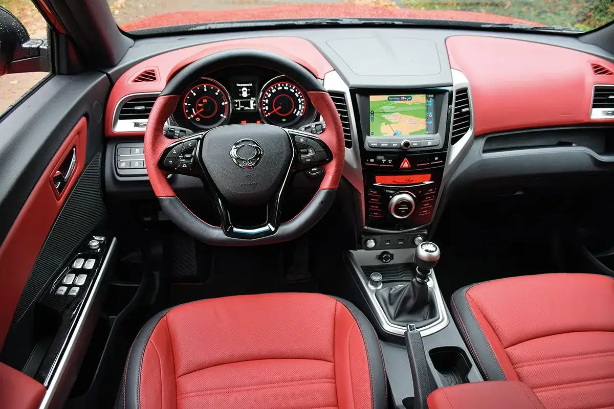 Wnętrze SsangYong Tivoli z czerwonymi skórzanymi fotelami i kierownicą. Wiele osób szuka ssangyong tivoli opinie, by poznać ten model.