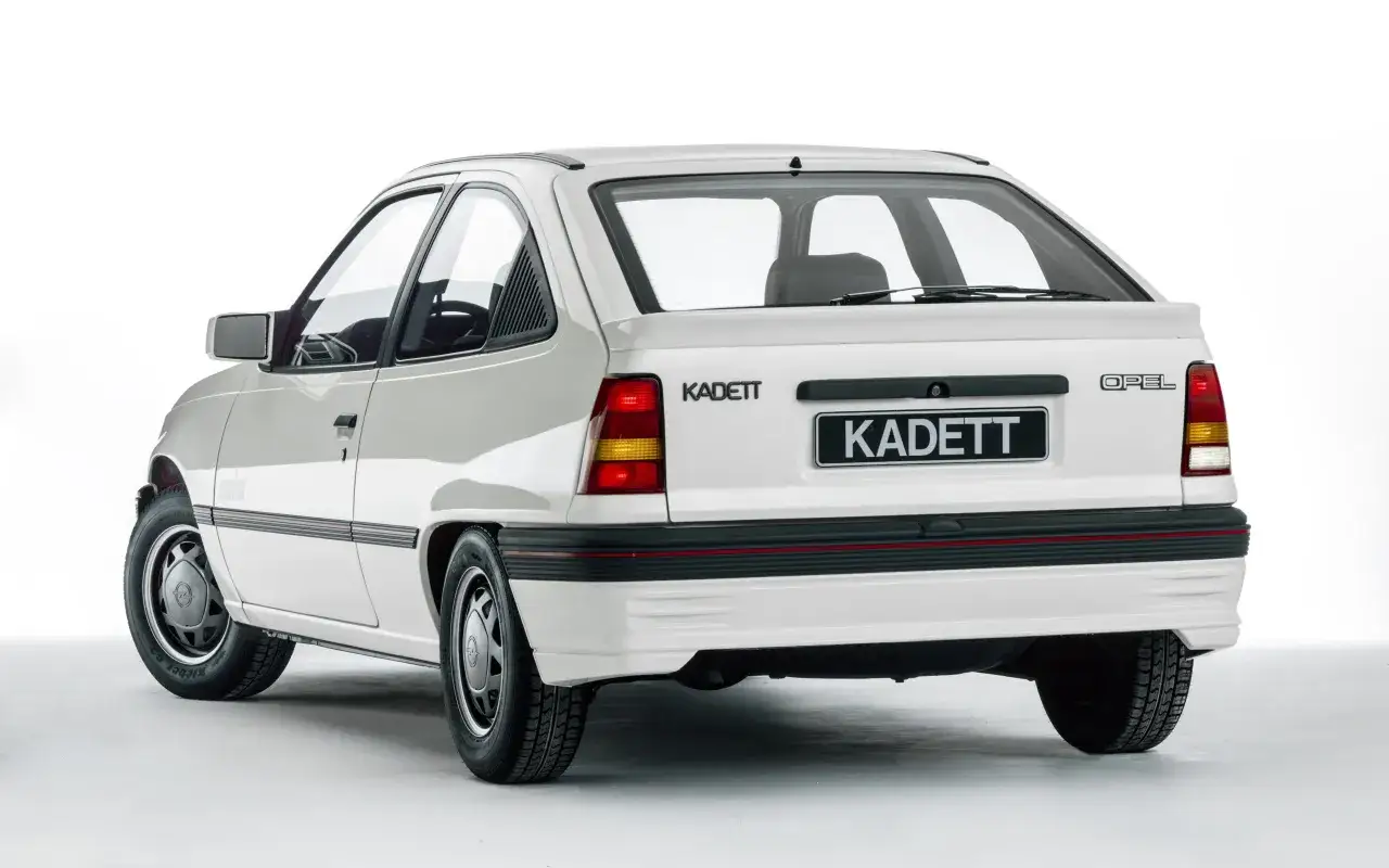 Biały Opel Kadett z lat 80. z charakterystycznym spojlerem i naklejką 