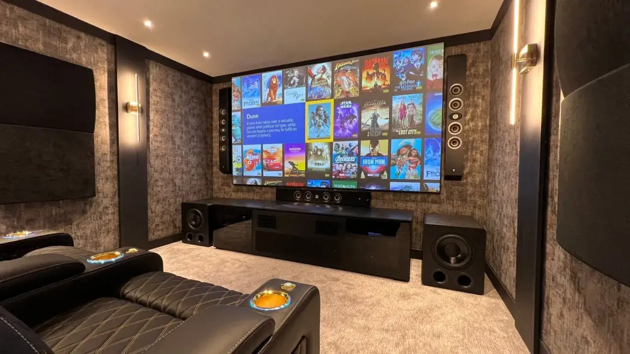 Luksusowy pokój kinowy z wygodnymi fotelami i ekranem pełnym filmów. Idealne miejsce na seans w stylu multiroom.