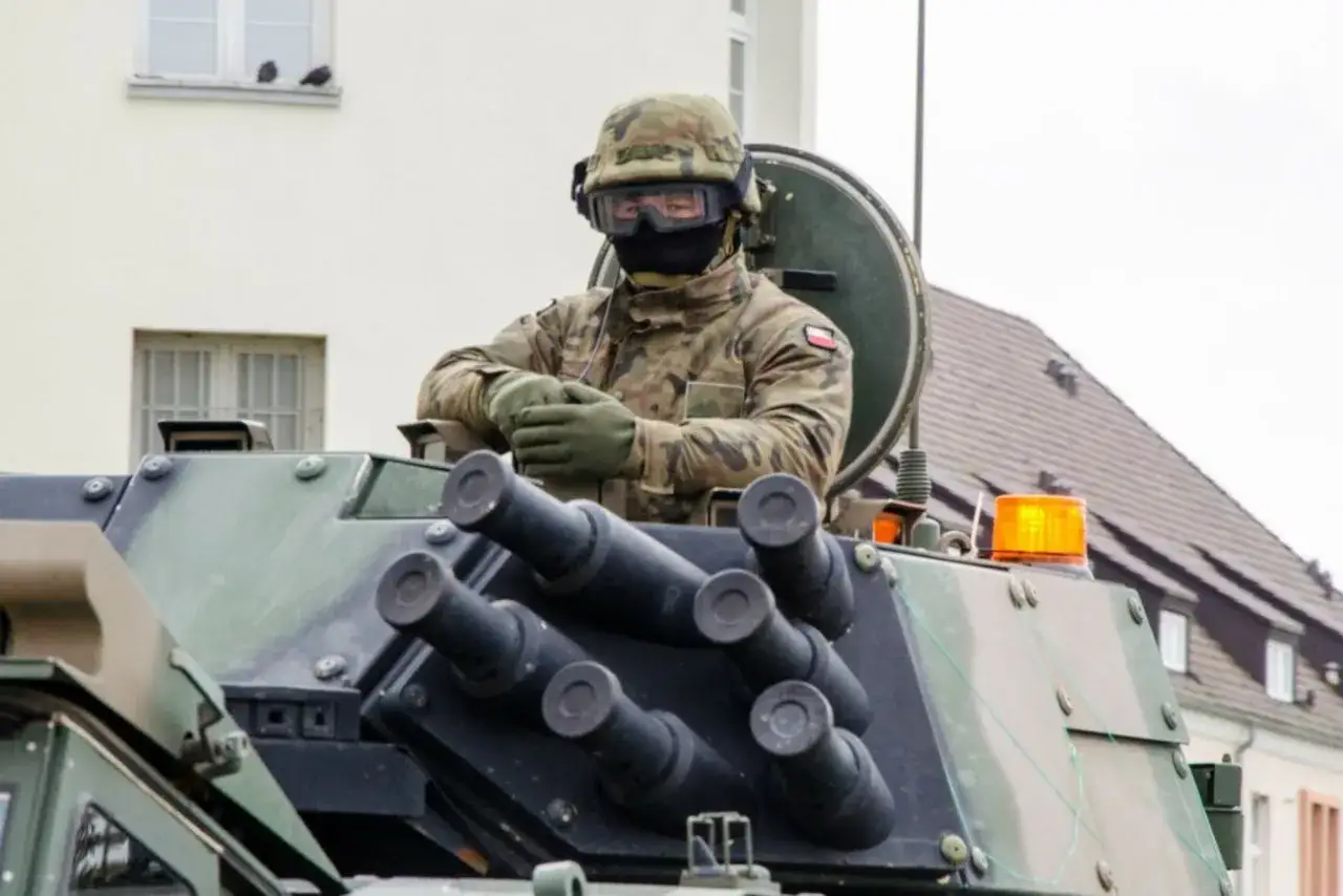 Żołnierz w kamuflażu, w hełmie i goglach, siedzi w pojeździe opancerzonym. To jego zasadnicza służba wojskowa.