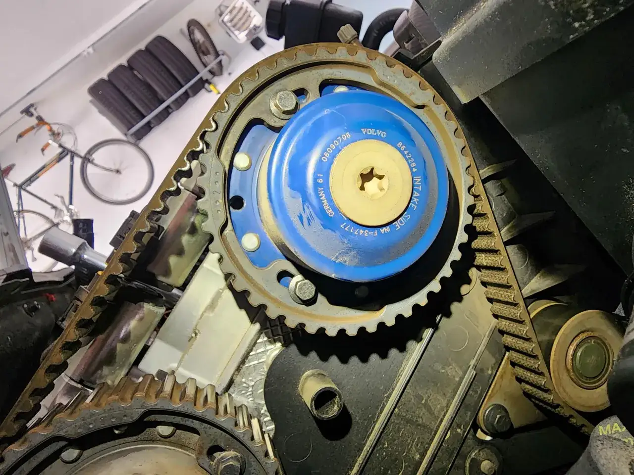 Widok z bliska na ustawienie rozrządu Volvo 2.5 turbo. Widoczny niebieski napinacz INA i zębatka.