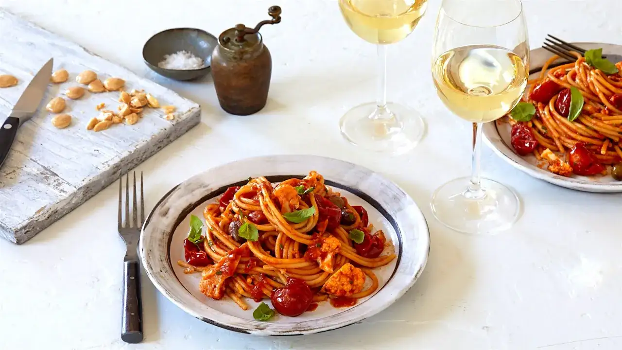 Två glas vitt vin till en härlig pasta med tomatsås, blomkål och oliver. En perfekt middag!