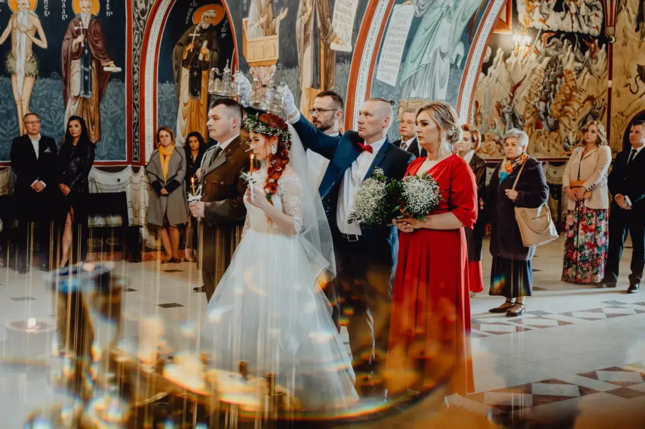 Ślub prawosławny w cerkwi. Czy kości&oacute;ł katolicki uznaje ślub prawosławny? Para młoda w koronach, świadkowie, goście.