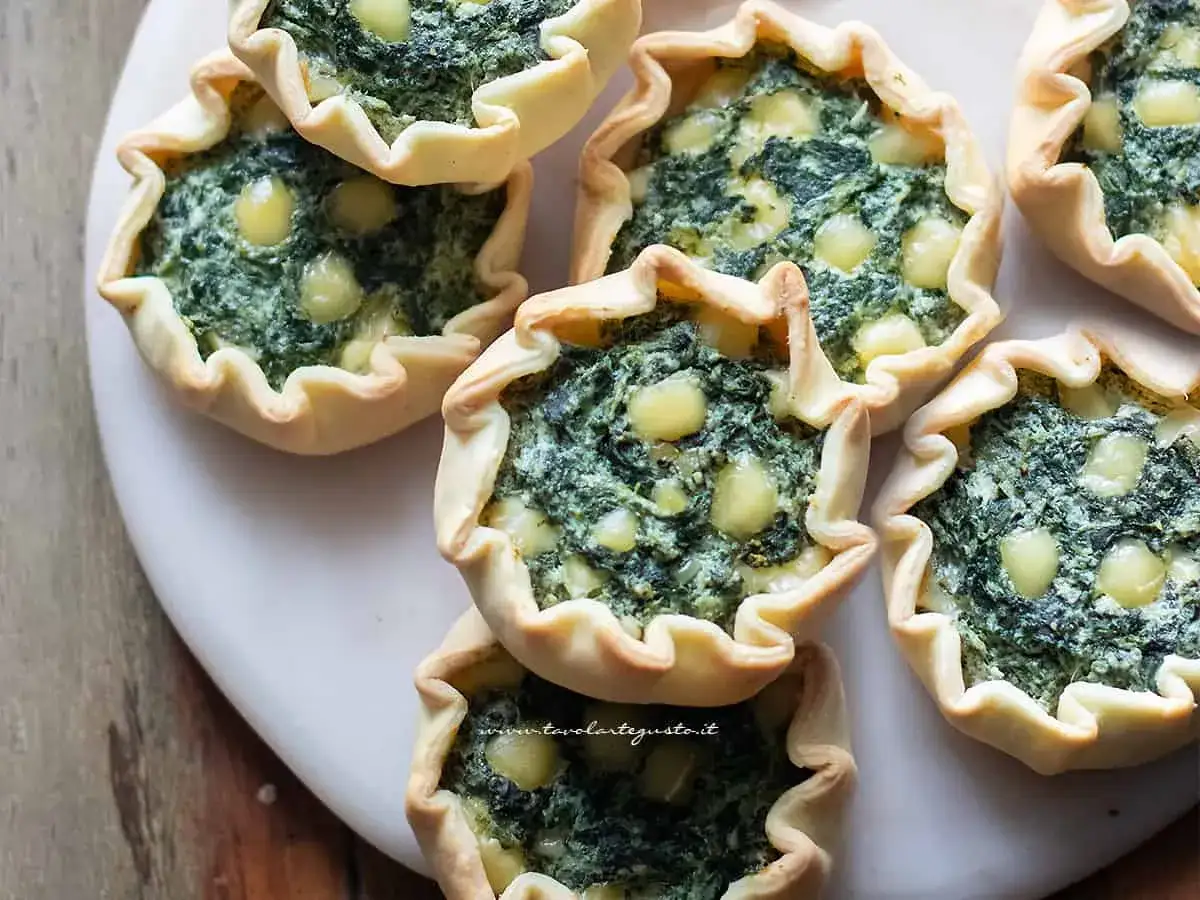 Deliziose tortine salate con ripieno cremoso di ricotta e spinaci, perfette per un antipasto o uno spuntino.