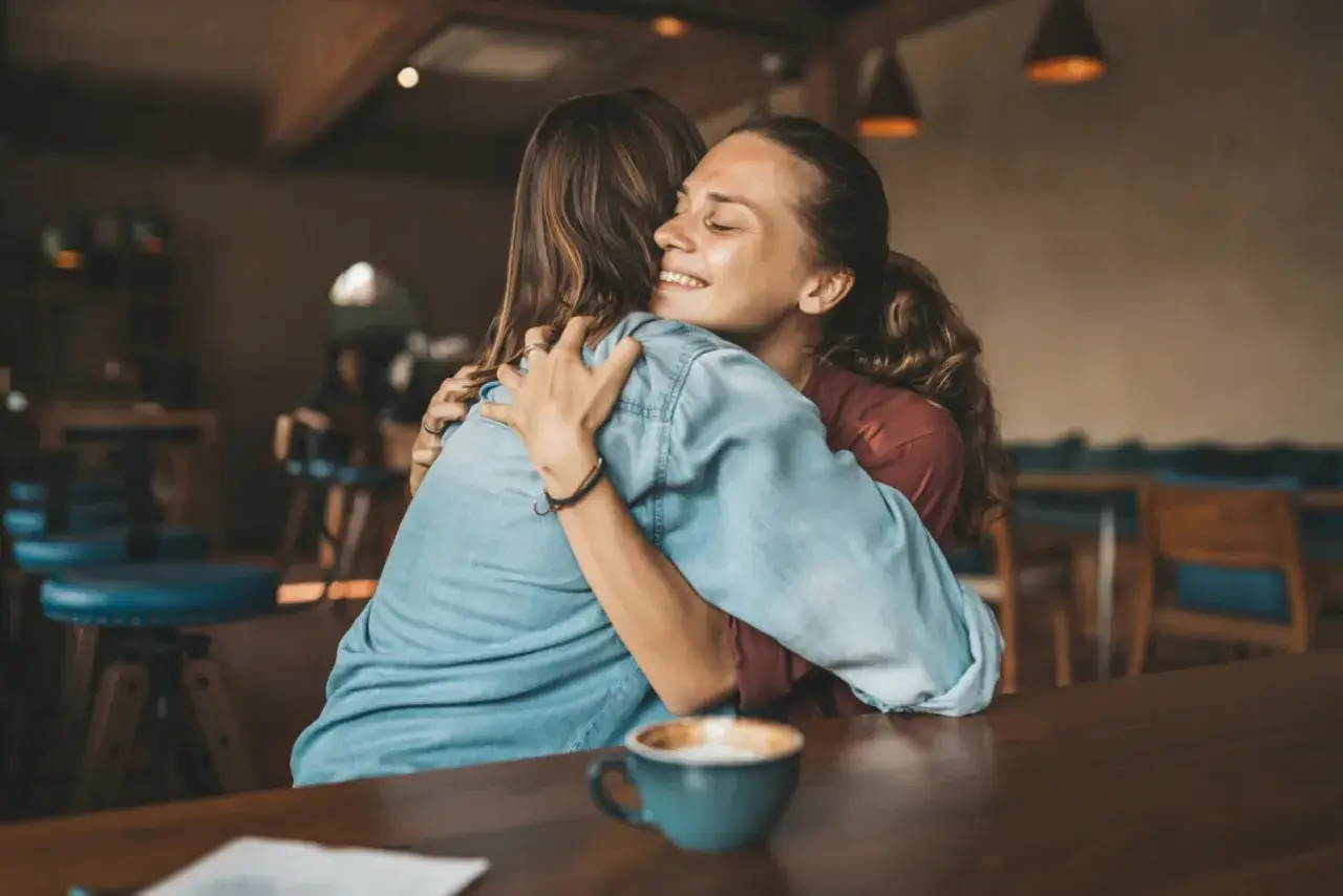 Deux femmes s'enlacent tendrement. Un geste d'amour et de pardon, peut-être pour comment reconquérir sa femme après l'avoir déçu.
