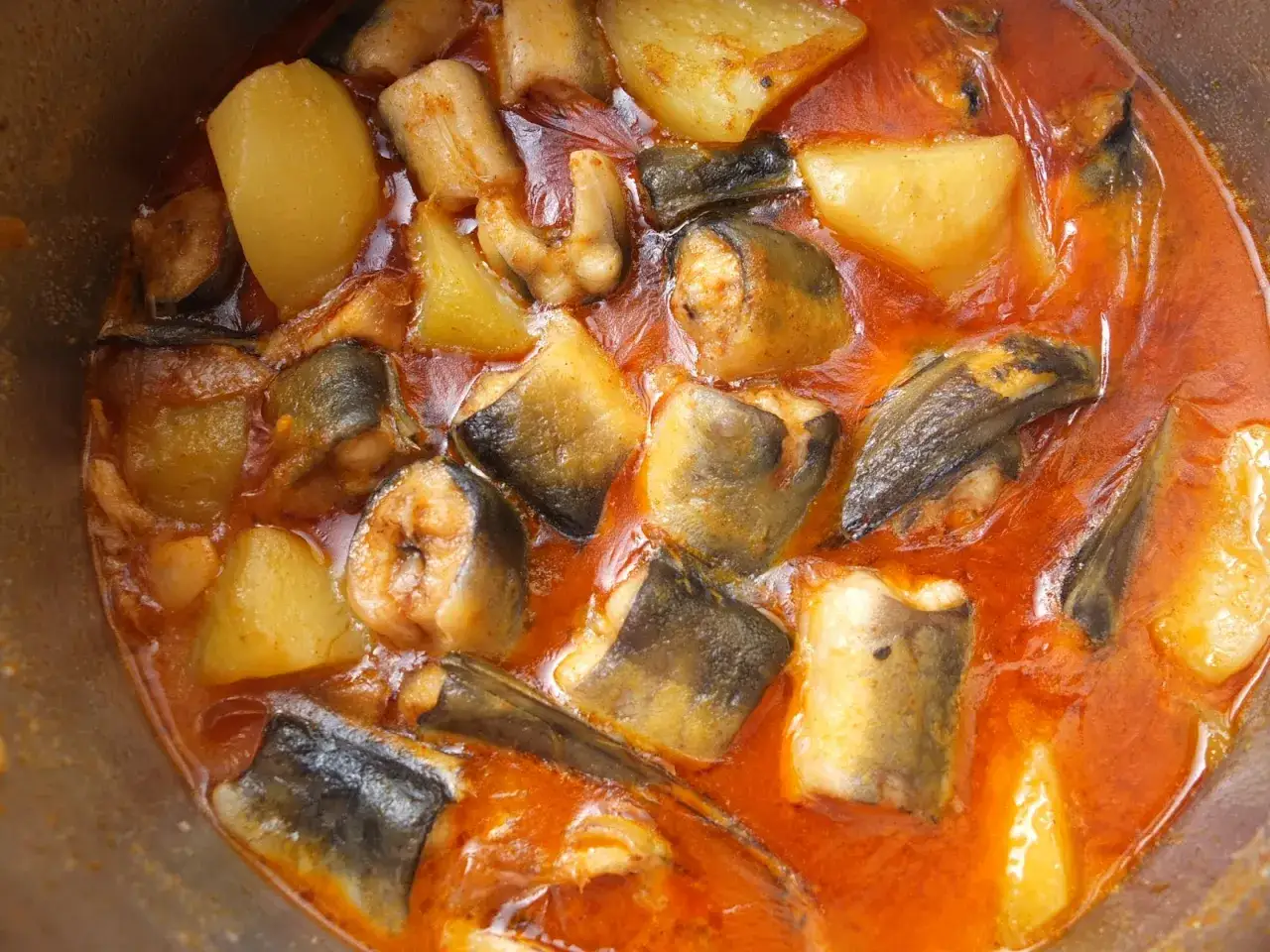 Un sabroso all i pebre con trozos de anguila y patatas en una cazuela.