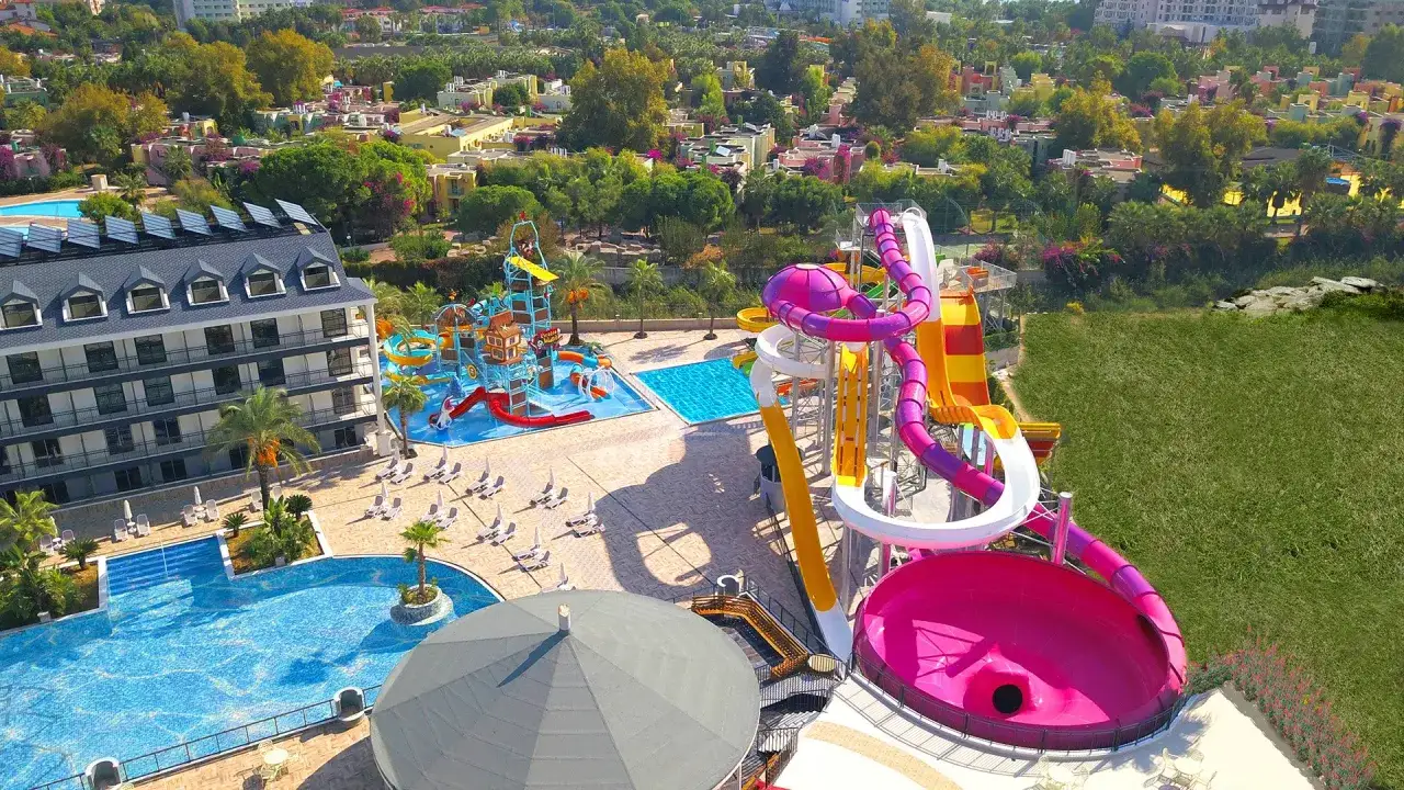 Kolorowy park wodny z hotelowym kompleksem, basenami i zjeżdżalniami, jak z **dream world palace**.