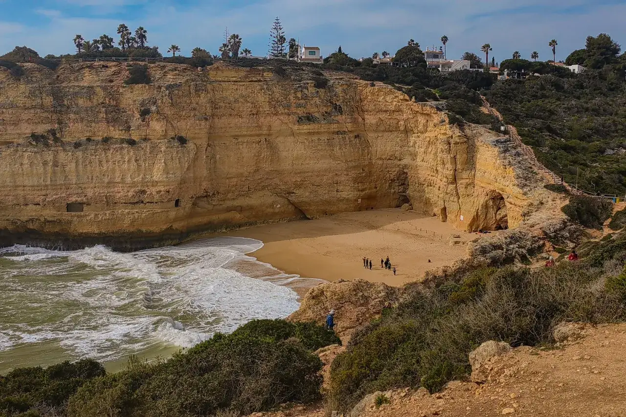 Malownicza plaża z klifami i jaskiniami, idealne miejsce, by zobaczyć Algarve. Woda i piasek tworzą piękny krajobraz.