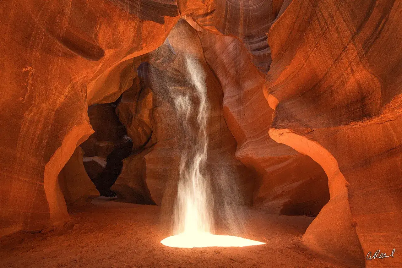 Raggio di luce illumina la sabbia in un canyon, creando un effetto magico. Questa foto pi&ugrave; costosa al mondo cattura la bellezza effimera della natura.