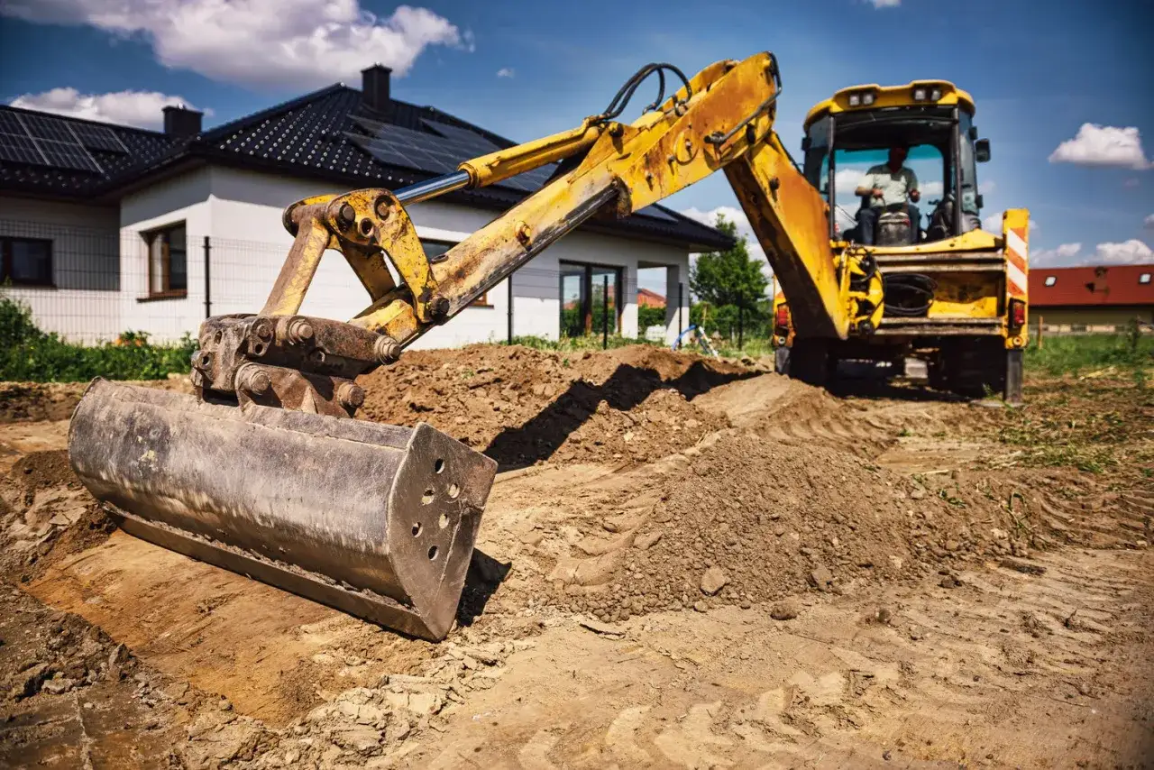 Koparka pracuje na budowie domu. Zastanawiasz się, ile waży m3 piasku? To zależy od wilgotności, ale średnio ok. 1500-1700 kg.