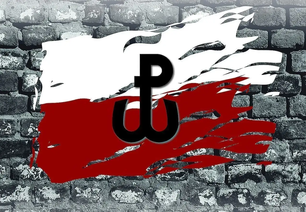 Symbol Polski Walczącej na tle zniszczonej ceglanej ściany. Kotwica symbolizuje nadzieję i walkę o wolność.