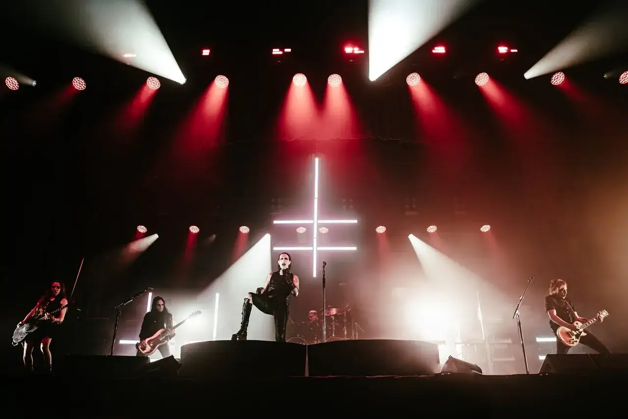 Marilyn Manson zesp&oacute;ł na scenie, w otoczeniu czerwonych i białych świateł, z charakterystycznym krzyżem.
