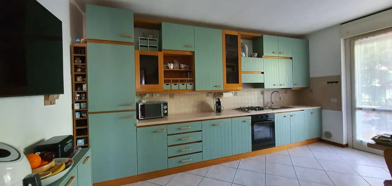 Cucina con ante in legno verniciate di azzurro, un progetto di restyling per rinnovare l'aspetto.
