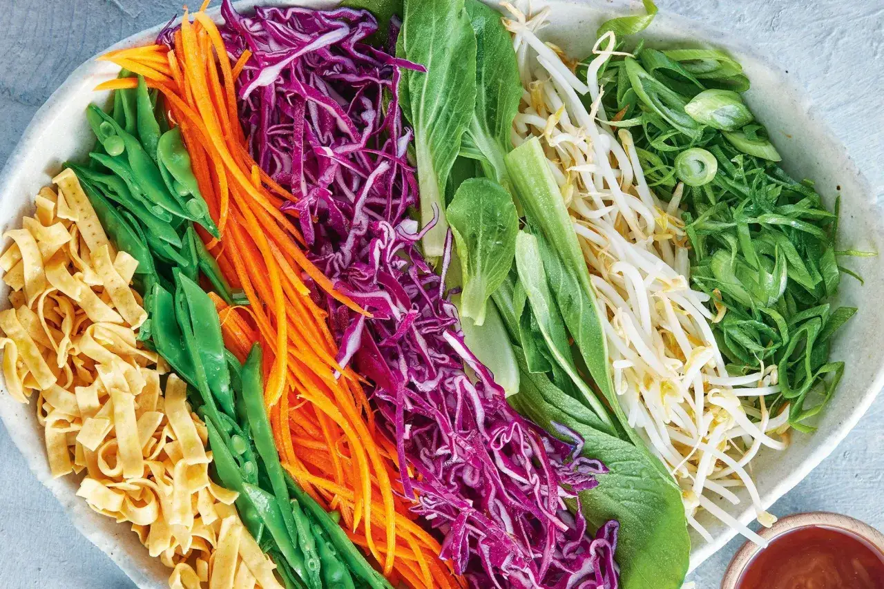 En sk&aring;l med f&auml;rgglad asiatisk nudelsallad: strimlade nudlar, socker&auml;rtor, mor&ouml;tter, r&ouml;dk&aring;l, pak choi, b&ouml;ngroddar och salladsl&ouml;k.