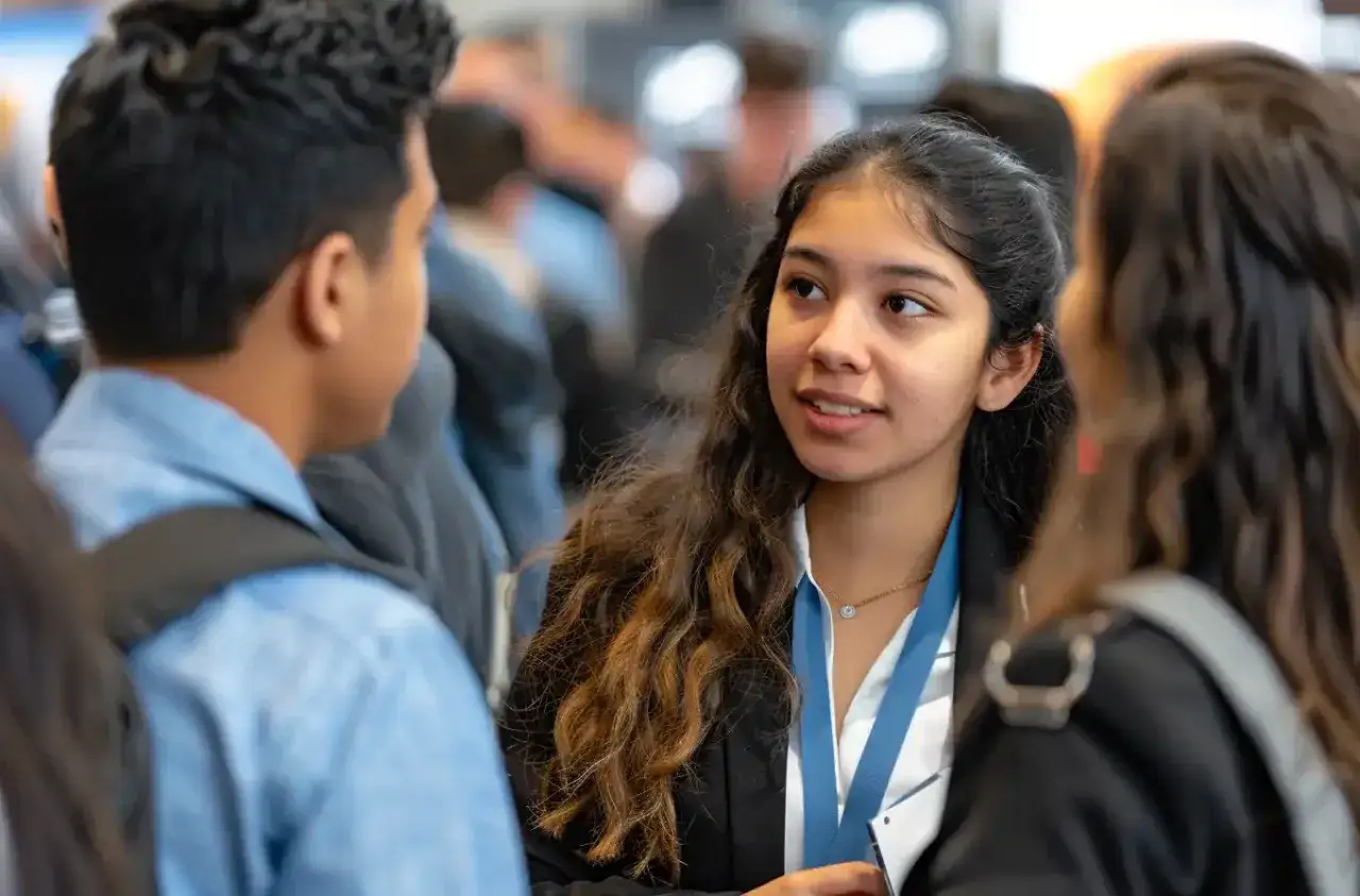 Jóvenes conversando, quizás compartiendo experiencias sobre las ventajas de estudiar en el extranjero.