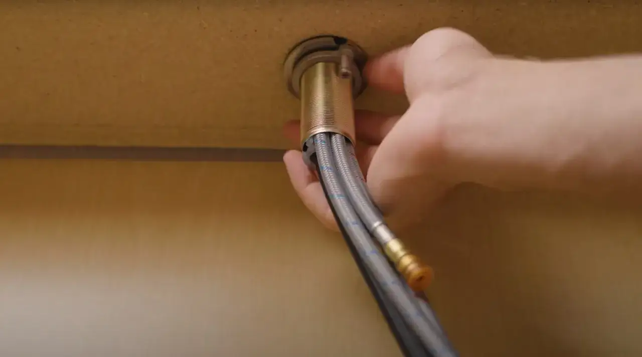 Tightening the mounting nut on a new kitchen faucet. This step is crucial when learning how to replace kitchen faucet.