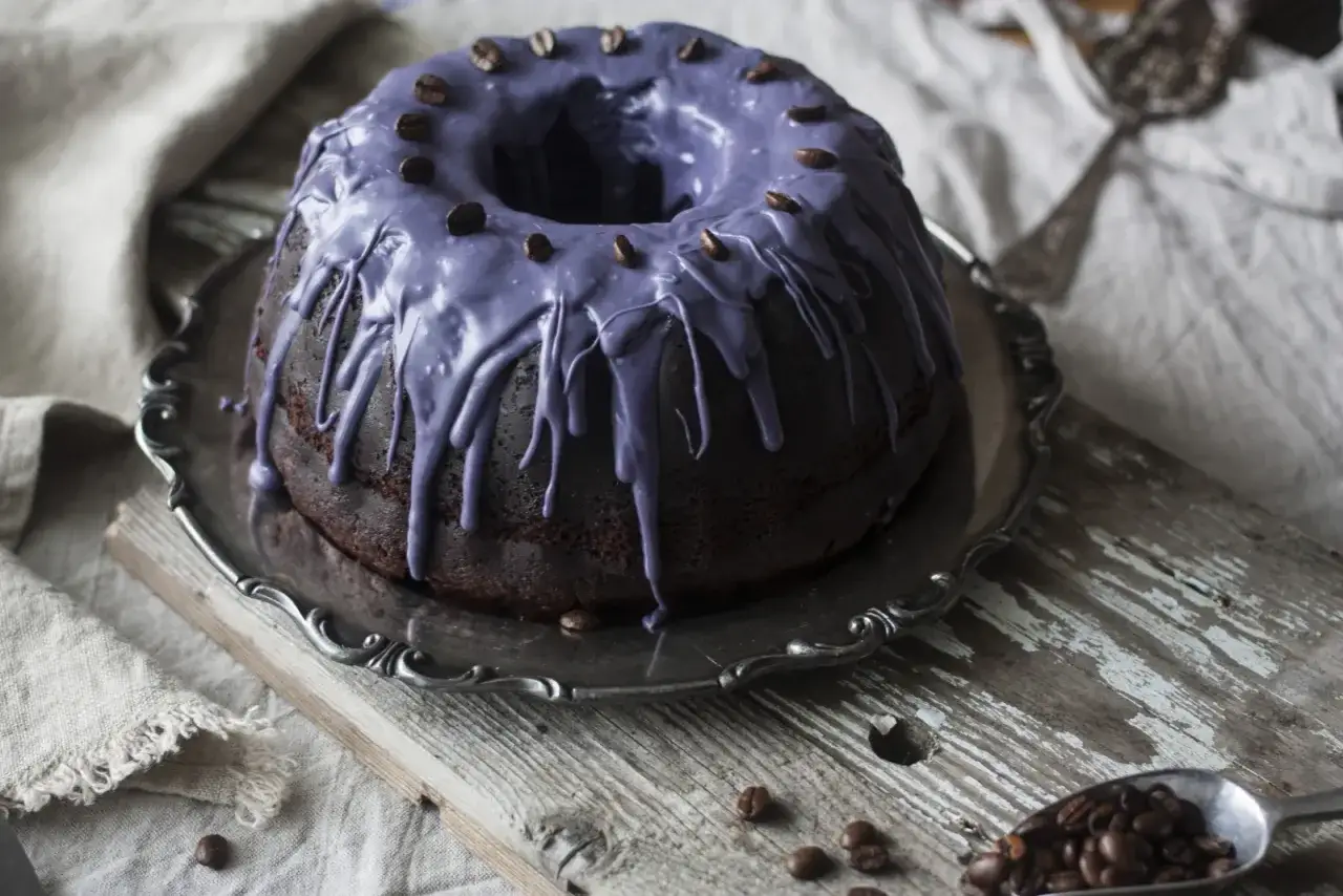 M&ouml;rk chokladkaka med lila glasyr och kaffeb&ouml;nor, perfekt f&ouml;r ett chokladkaka recept.