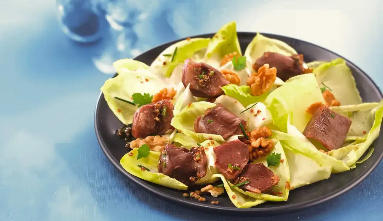 Salade de g&eacute;siers savoureuse sur lit d'endives, parsem&eacute;e de noix croquantes et de persil frais. Un d&eacute;lice !