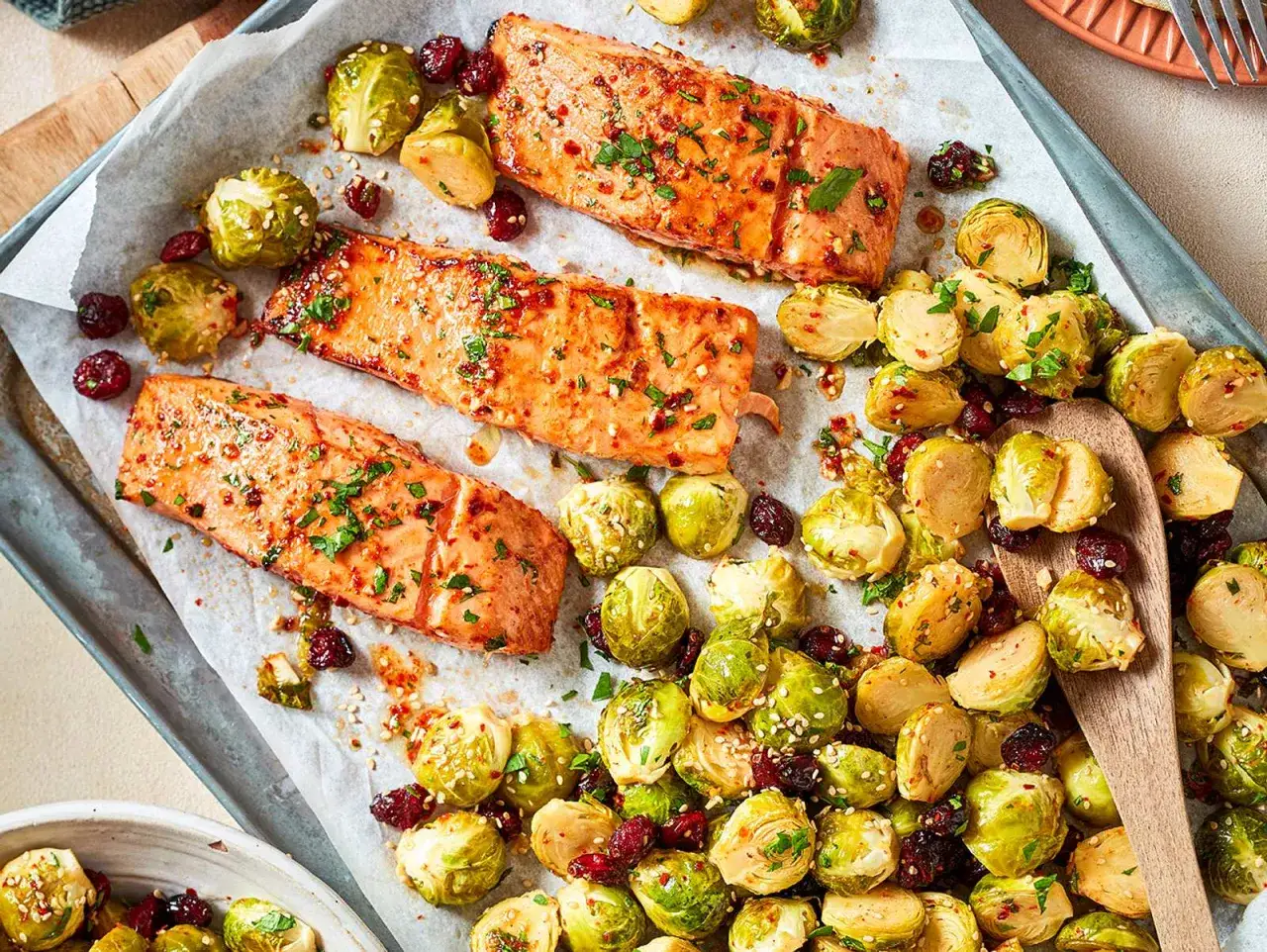 Drei saftige Lachsfilets mit glasierten Rosenkohlröschen und Cranberries. Leckere Fische, perfekt zubereitet.