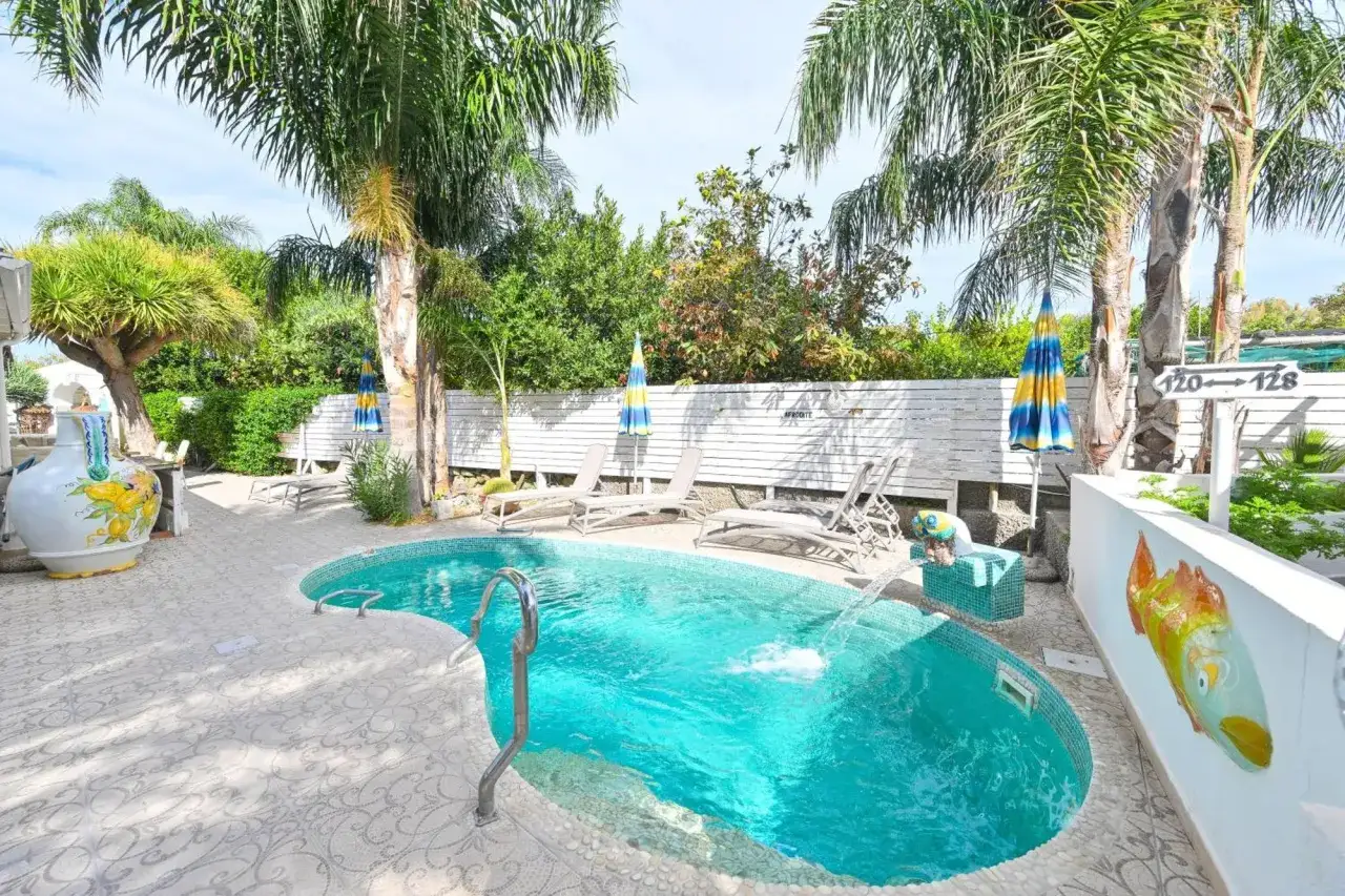 Piscina cristallina e palme rigogliose al Park Hotel La Villa Ischia. Le recensioni lodano questo angolo di paradiso.