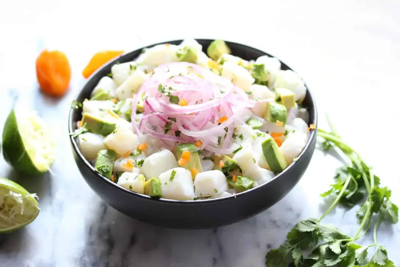 Un d&eacute;licieux ceviche de poisson frais, garni d'oignons rouges, d'avocat et de coriandre.