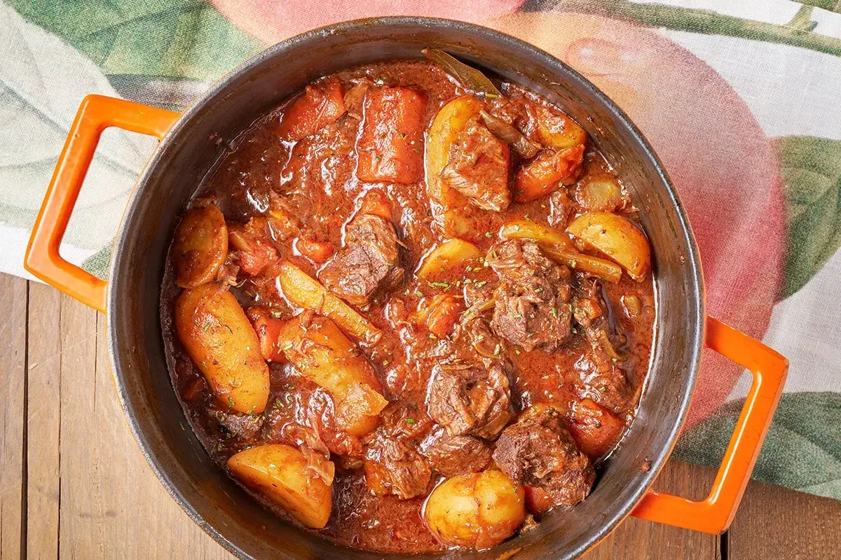 Un invitante spezzatino di vitello cotto lentamente in un tegame di ghisa, con patate e carote succulente.