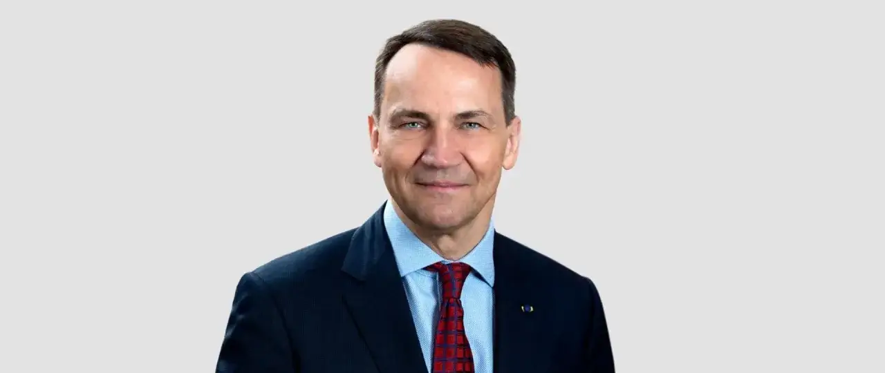 Radosław Sikorski, polityk, który budzi pytania: Sikorski jaka partia? Uśmiechnięty mężczyzna w garniturze.