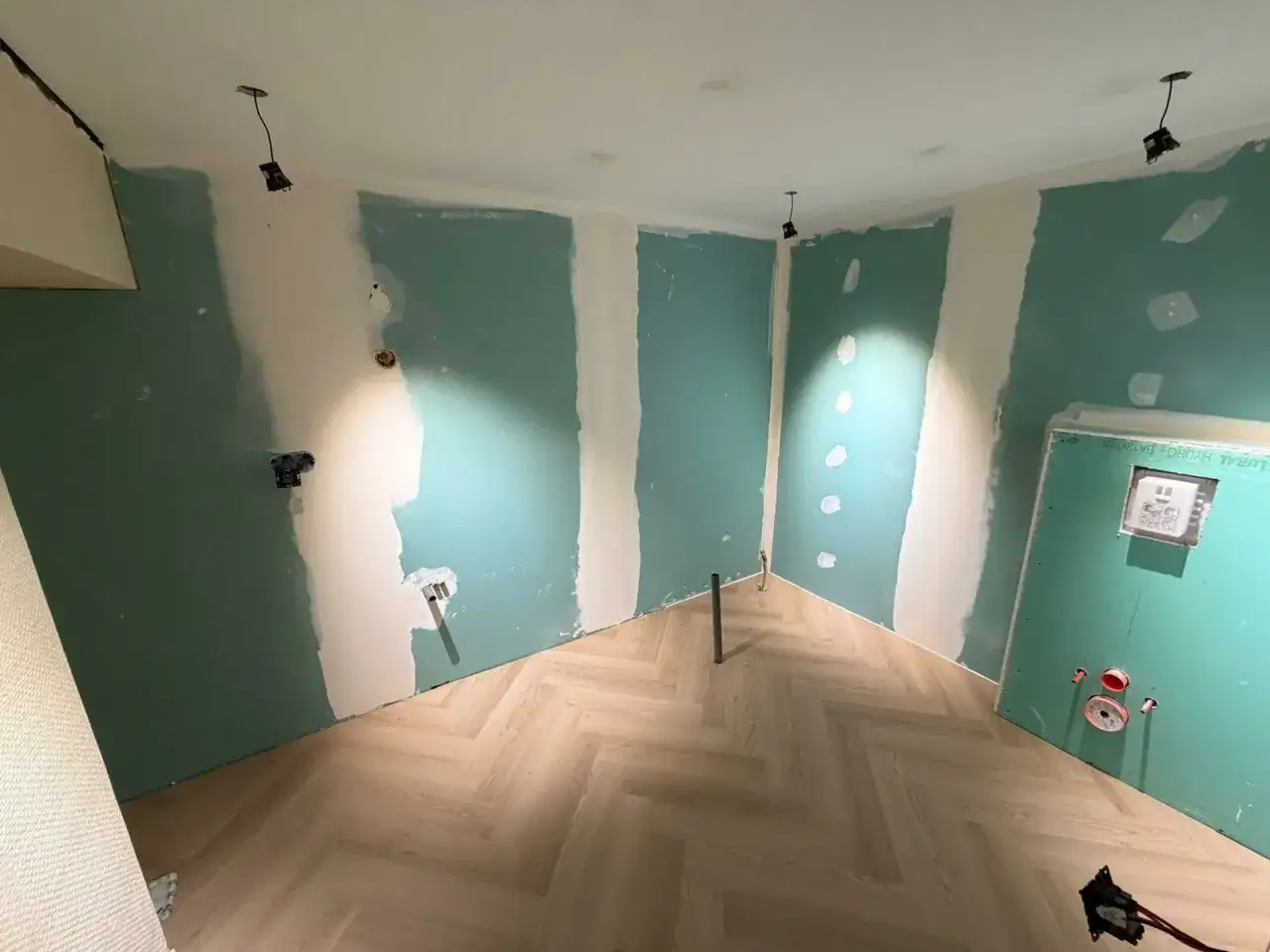 Chantier en cours : murs en Placo vert, sol parquet chevrons. Idéal pour estimer le prix pose placo m2.