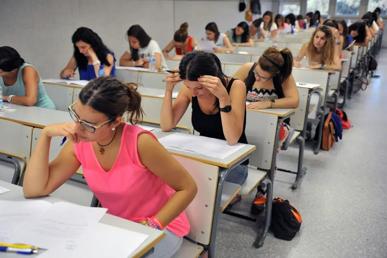 Estudiantes concentradas en un examen, preparándose para sus oposiciones con grado medio.