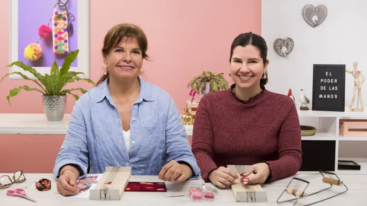 Due donne sorridono, pronte per i **corsi per creare bijoux**. Sul tavolo, materiali colorati e attrezzi per dare vita a creazioni uniche.